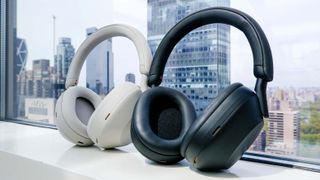 Sony WH-1000XM5 Black and ecru (off-white) color versions against a office window