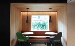 Two tables and chairs in a private, boxed space, with a window looking out into the garden