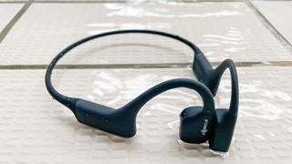 Shokz OpenSwim poolside in a puddle