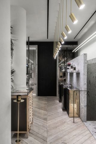 Shop interior of Greek Jewellery designer Ileana Makri with wooden floors, black cabinets, glass display cabinets and gold mirrors