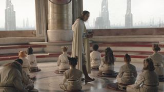 a man in a robe walks among a group of seated children