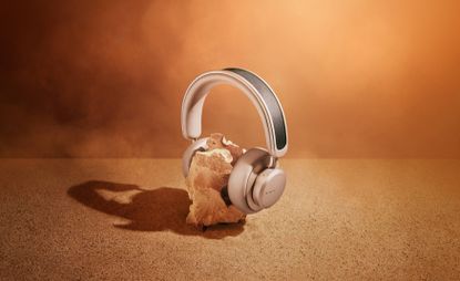 Headphones over a rock, against neutral background