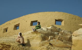 People sat outside a building wall