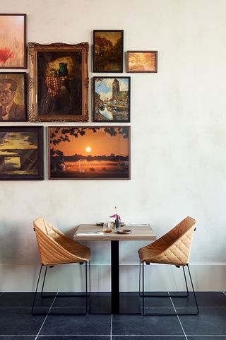 Inside table and chairs with wall of picture frames