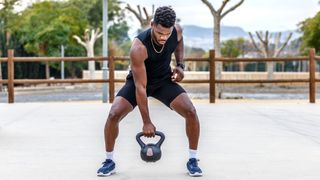 Man bending to pick up a kettlebell