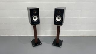 Triangle Capella speakers in blue on stands against white wall