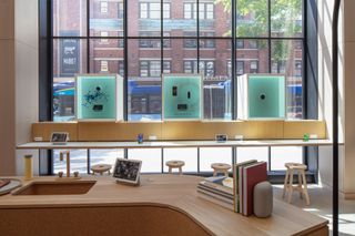 A view from inside Google's Store, with a wooden desk with tablets and books in the foreground