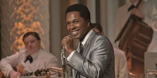 Sam Cooke (Leslie Odom Jr.) smiles as he holds a microphone in &#039;One Night in Miami&#039;