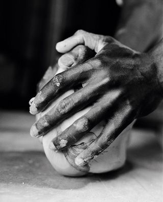 King Houndekpinkou kneads the clay for hours to remove any air bubbles, like a baker preparing a perfect dough 