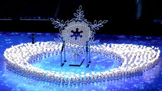 orch bearers carry the Olympic flame during the opening ceremony of the Beijing 2022 Olympic Games at the National Stadium