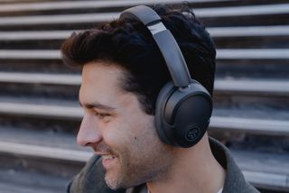 JLab Lux wireless headphones being worn by a man with dark hair