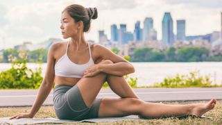 woman doing hip stretch outside 