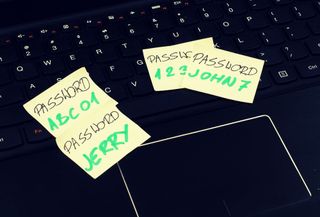 Passwords written on Post-It notes on a laptop computer keyboard.