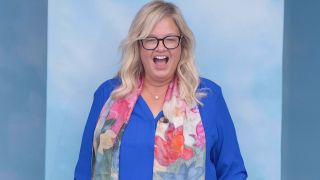 Angela Murray looking joyous in a blue shirt and floral scarf in Big Brother on CBS