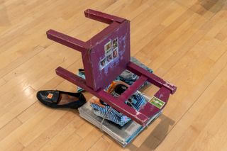 fallen red chair with newspaper on wooden floor