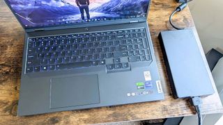 Lenovo Legion Pro 5i (Gen 9) power adapter next to laptop.