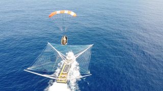 The net-equipped SpaceX boat GO Ms. Tree catches a Falcon 9 payload fairing half on Aug. 18, 2020.