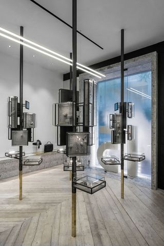 Shop interior of Greek Jewellery designer Ileana Makri with wooden floors, black cabinets, glass display cabinets and gold mirrors