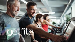 Personal trainer helping older man on treadmill