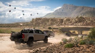 Screenshot of Forza Horizon 5 depicting trucks driving across the desert.