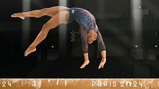 Simone Biles does a backflip along the balance beam at the 2024 Paris Olympic Games.