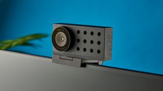 A photograph of the Opal C1 in black, mounted on a monitor with a blue background. 