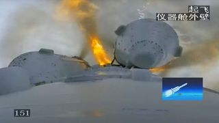 a top-down view of a rocket launching as seen from a camera on the rocket. a long grey metal tube stretches away from the camera, ending in a large plume of fire and smoke