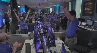 Members of NASA's OSIRIS-REx asteroid sample-return mission team celebrate after receiving word that the probe completed an attempt to collect samples of asteroid Bennu 207 million miles from Earth on Oct. 20, 2020. 