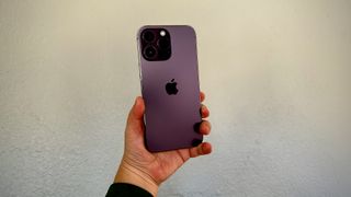 Someone holding up an iPhone 14 Pro in deep purple.