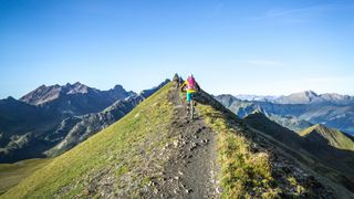 Two people bike up a mountain