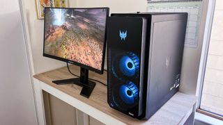 Gigabyte G27FC monitor alongside Acer Predator Orion 7000 on a desk