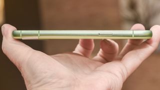 Google Pixel 8a in aloe green from side showing SIM card slot