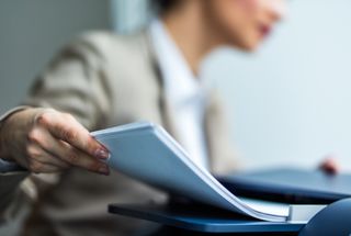 Business woman feeding paper into printer