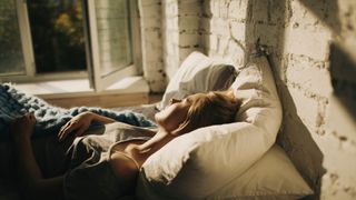 The image shows a woman sleeping in bed with her window open in Lüften’, a German sleep hack