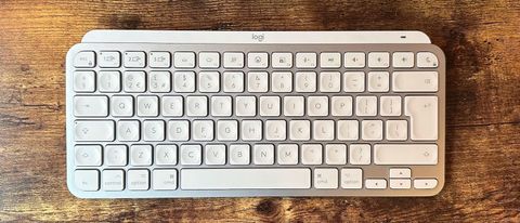 The Logitech MX Keys Mini for Mac keyboard on a wooden desk