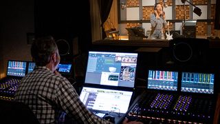A sound engineer using Dolby Atmos Music on a studio mixer