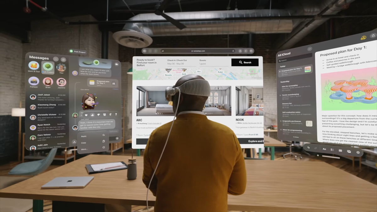Man working on multi-window experience on Apple Vision Pro while sitting at a desk