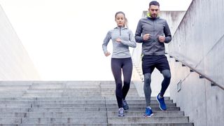 Man and woman side by side walking down steps during workout