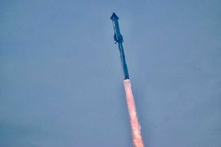 a large silver rocket flies through a blue sky above a large plume of fire