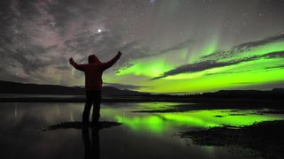 Chad Blakley under the northern lights, shining green.