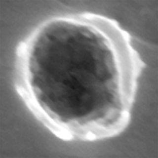 This image shows a top-down view of a dust particle impact on NASA's Stardust spacecraft Al foil collector.