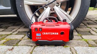 Craftsman V20 Cordless Tire Inflator next to car tire