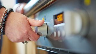 Someone adjusting the settings on an oven