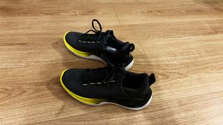 Under Armour Flow Dynamic training shoe against wooden background