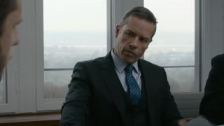 Guy Pearce sits in conversation at a conference table dressed in a suit in Tom Clancy's Without Remorse.