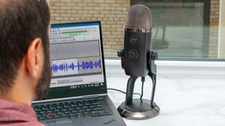 Listing image for best USB microphones showing Blue Yeti X mic with laptop