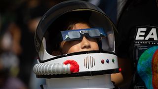  A child wearing an astronaut costume observes the Annular Solar Eclipse with using safety glasses at the facilities of the National Autonomous University of Mexico (UNAM) in Mexico City, Mexico on October 14, 2023