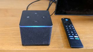 the Fire TV Cube (2022) with blue Alexa bar lit, and remote