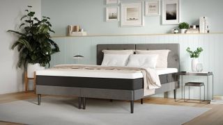 The Emma Original Mattress shown on a stylish grey fabric bed frame and dressed with pillows and throws