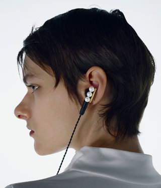 woman wearing earphone with pearls on